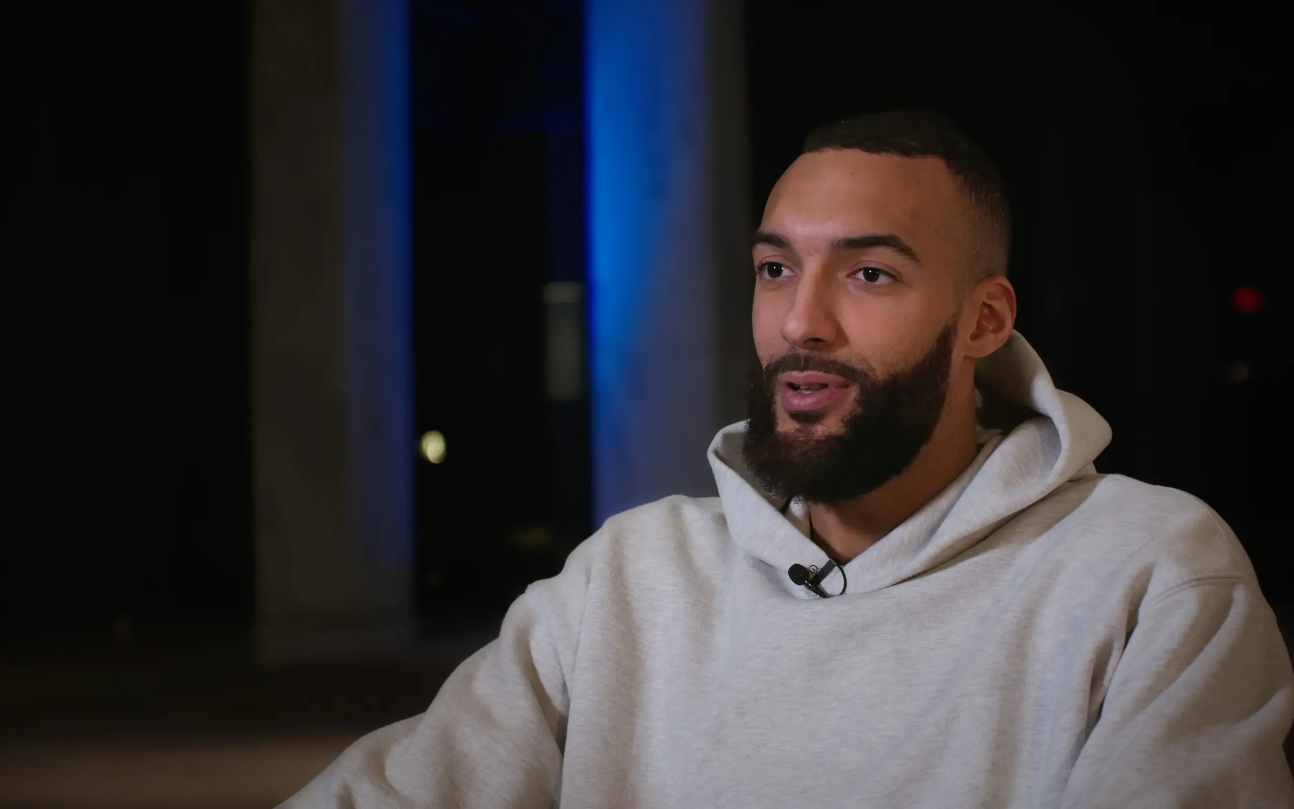 Athlete interviewed on a dark blue-lit set