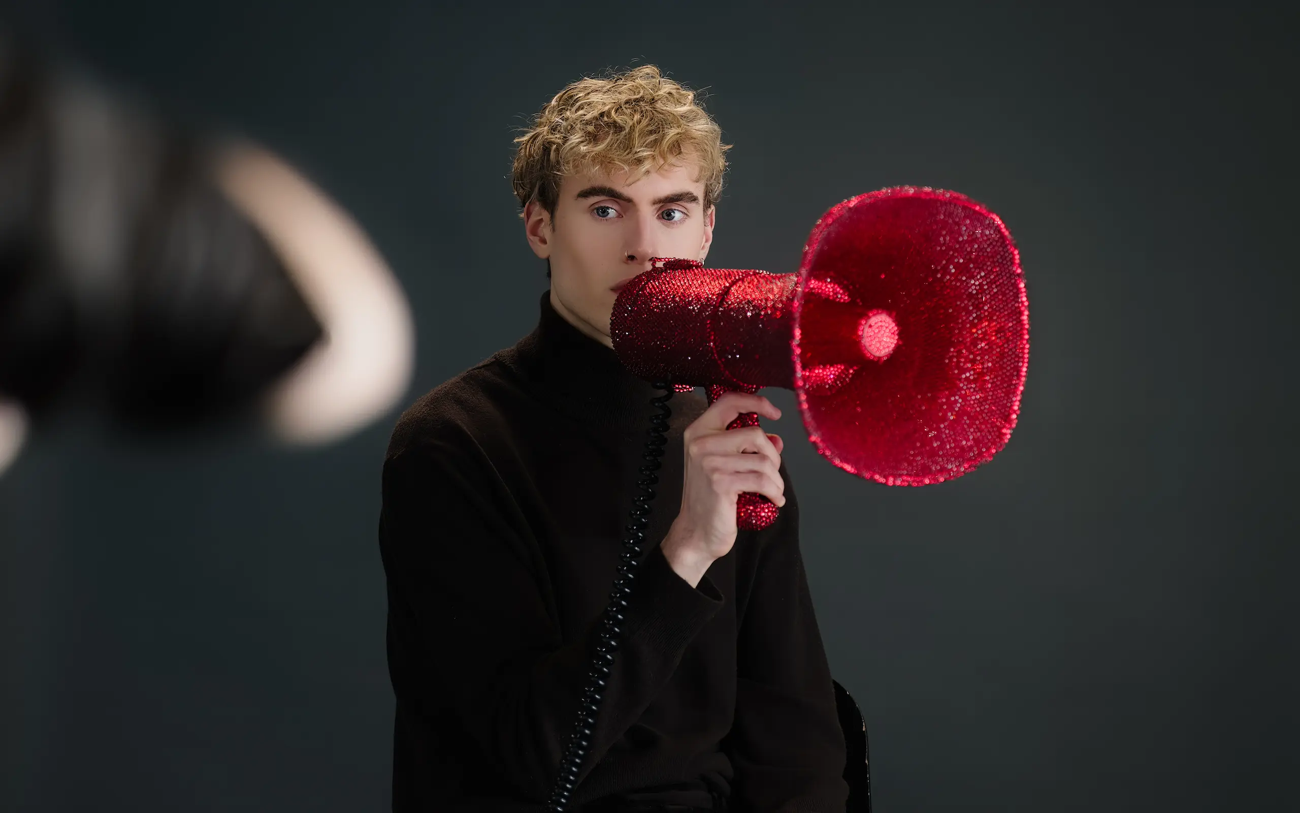 Activist with a crystal megaphone in a low-key studio